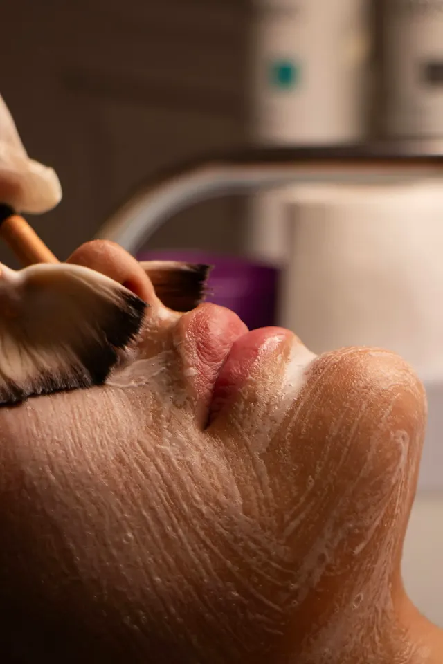 Un pincel aplica producto sobre el rostro durante el tratamiento