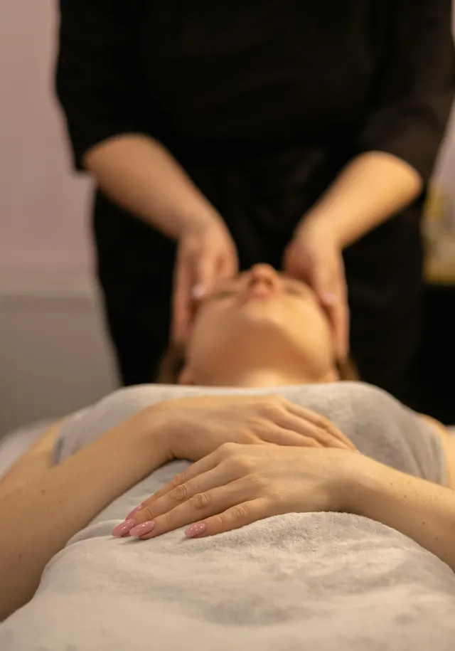 Una clienta recibe una valoración facial recostada en la camilla de cabina