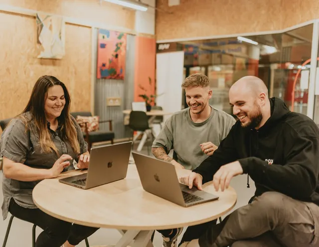Tres personas del estudio trabajando juntas alrededor de una mesa