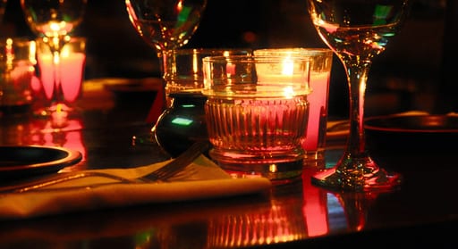 Mesa del restaurante de noche con velas encendidas y copas